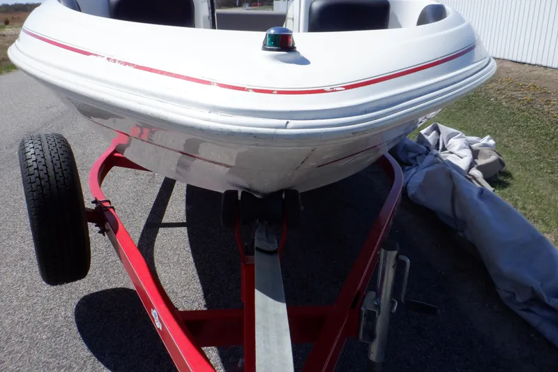 Slide: The Image of 2003 Glastron SX 195 boat on red trailer, front view, parked outdoors. - 18