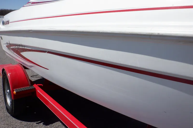 Slide: The Image of 2003 Glastron SX 195 boat with red accents on a trailer. - 23