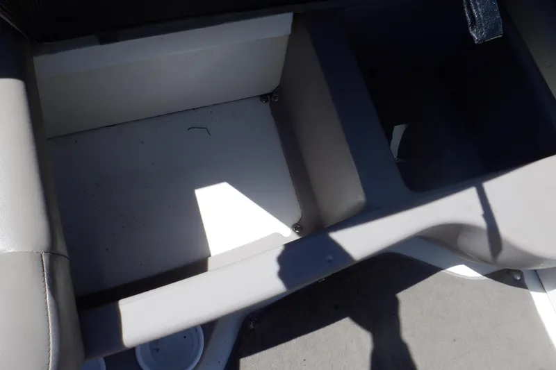 Slide: The Image of 2003 Glastron SX 195 boat interior storage compartment, featuring gray and white upholstery. - 45