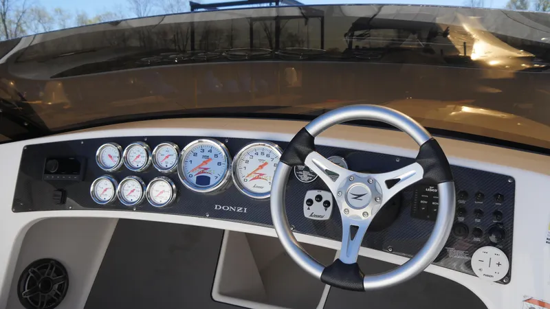 Slide: The Image of 2022 Donzi 22 Classic dashboard with gauges and steering wheel. - 11