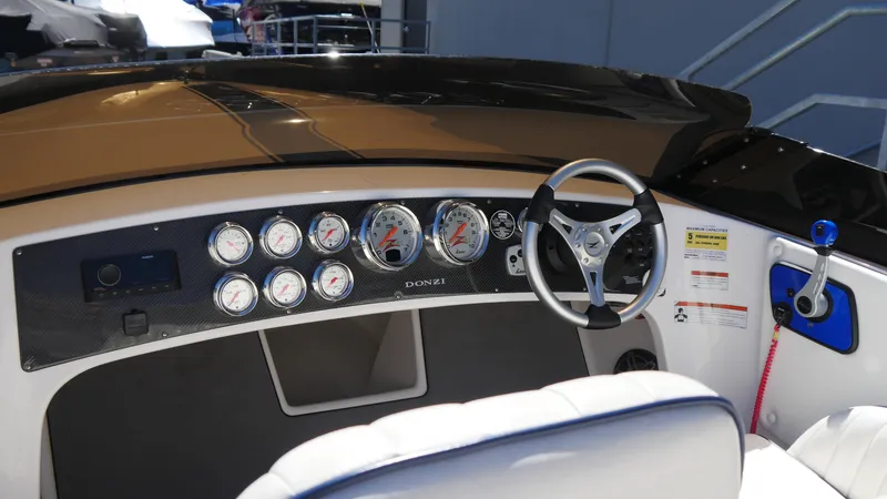 Slide: The Image of 2022 Donzi 22 Classic dashboard with gauges and steering wheel. - 13