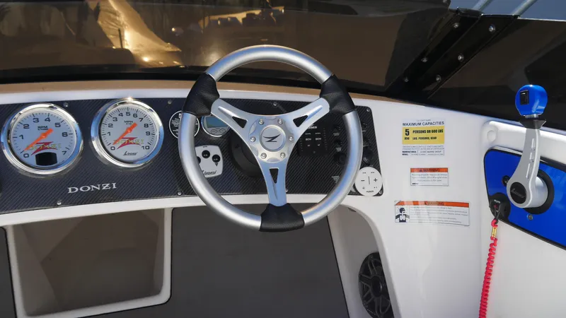 Slide: The Image of 2022 Donzi 22 Classic dashboard with steering wheel and gauges. - 14