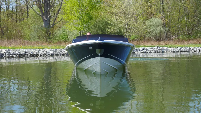 Slide: The Image of 2022 Donzi 22 Classic boat on calm water, surrounded by lush greenery. - 24