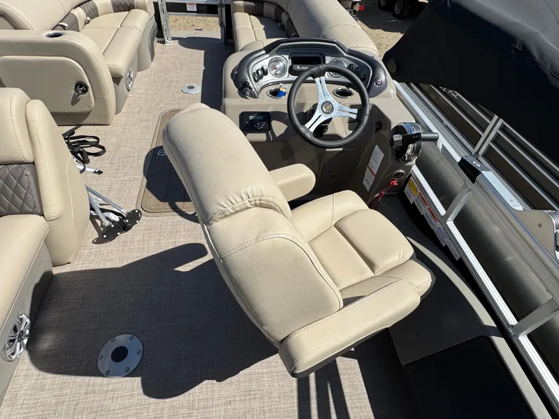 Slide: The Image of 2023 Sun Tracker SportFish 22 XP3 boat interior with beige seating and steering console. - 16