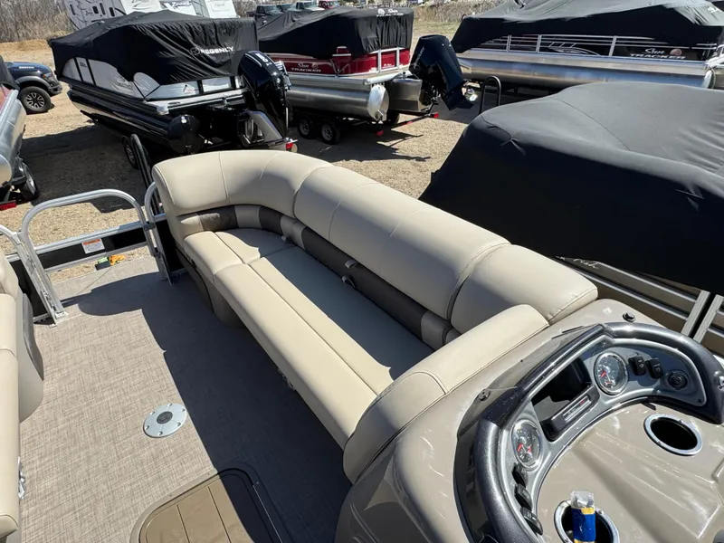 Slide: The Image of 2023 Sun Tracker SportFish 22 XP3 pontoon boat with beige seating and covered boats in background. - 18