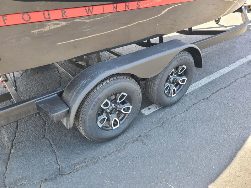 Slide: The Image of 2023 Four Winns H2 Surf boat trailer with dual wheels on asphalt. - 10