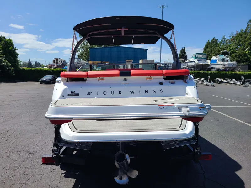 Slide: The Image of 2023 Four Winns H2 Surf boat, rear view, parked outdoors on a sunny day. - 5