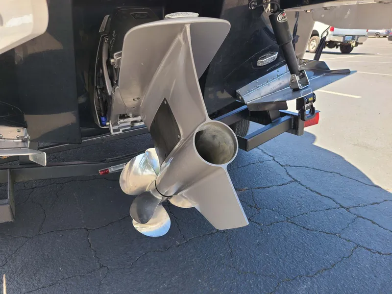 Slide: The Image of 2023 Four Winns H2 Surf boat propeller and stern detail in a parking lot. - 7