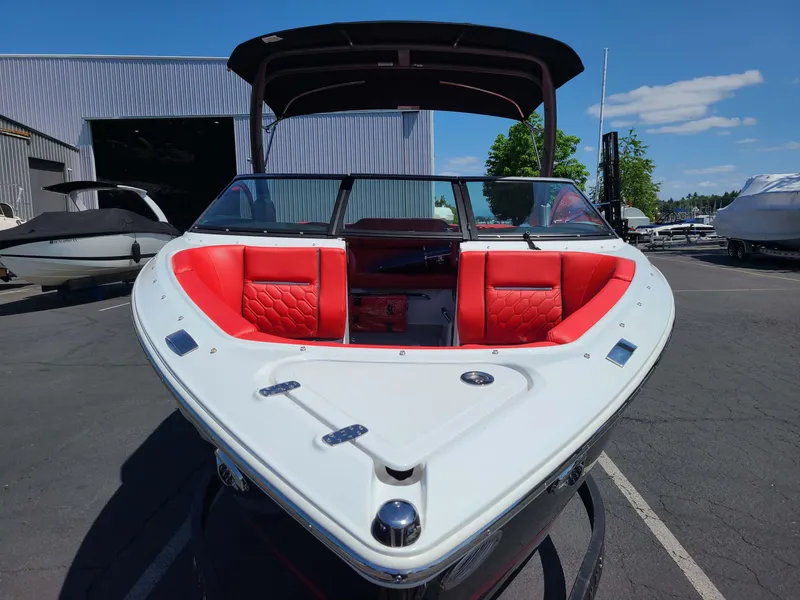 Slide: The Image of 2023 Four Winns H2 Surf boat with red seating, docked outdoors. - 8