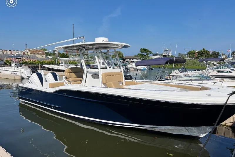 Slide: The Image of 2018 Buddy Davis 28 Center Console boat docked in marina, featuring sleek design and spacious seating. - 0