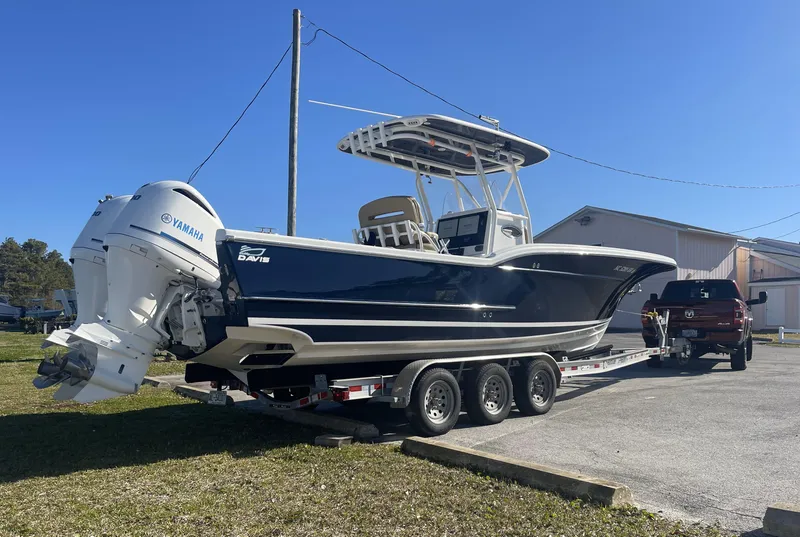 Slide: The Image of 2018 Buddy Davis 28 Center Console boat on trailer, parked outdoors, with Yamaha engines. - 1