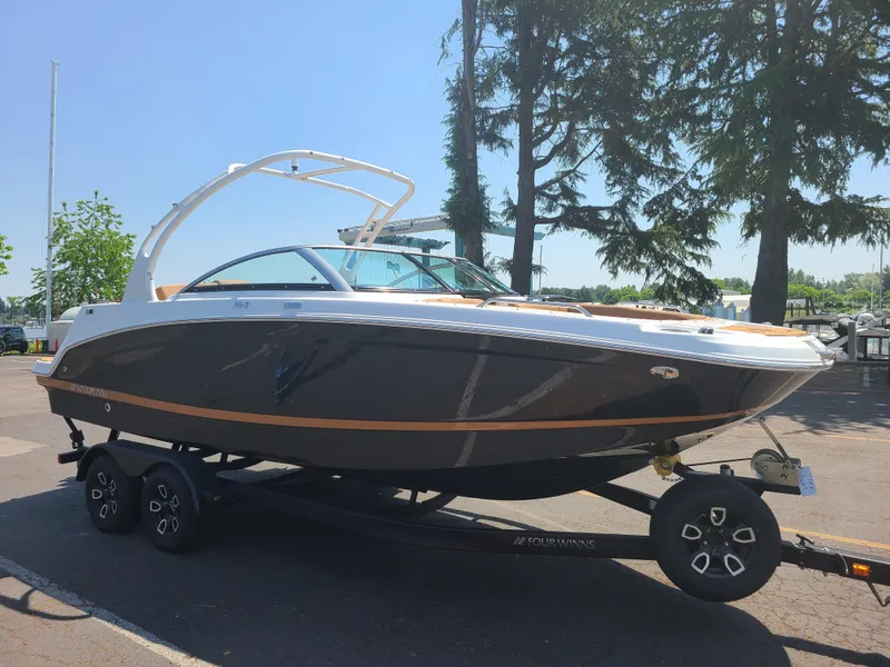 Slide: The Image of 2023 Four Winns HD3 boat on trailer, parked outdoors near trees. - 0