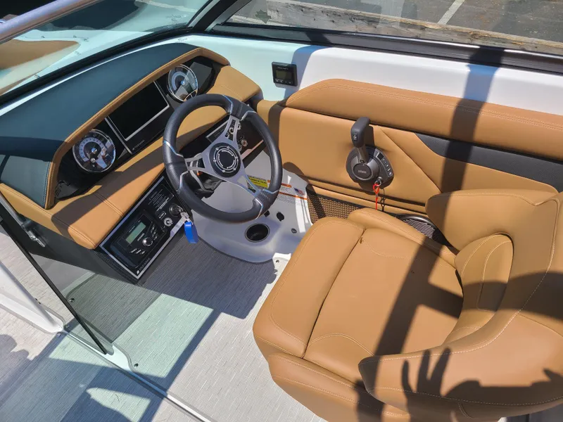 Slide: The Image of 2023 Four Winns HD3 boat cockpit with tan seating and modern dashboard controls. - 11
