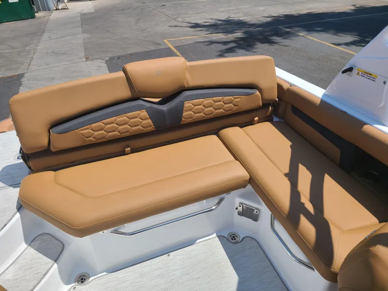 Slide: The Image of 2023 Four Winns HD3 boat with tan leather seating, outdoor setting. - 16