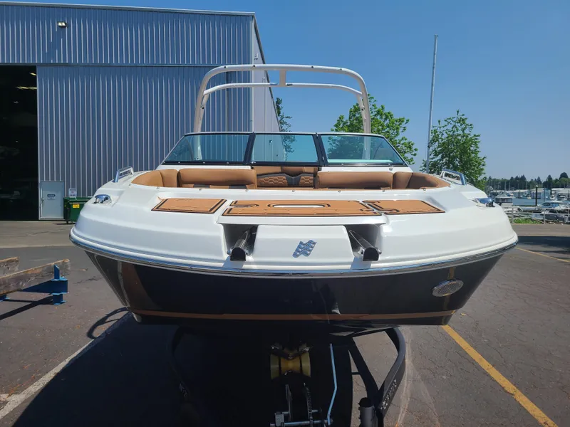 Slide: The Image of 2023 Four Winns HD3 boat, docked outdoors, front view with sleek design. - 2