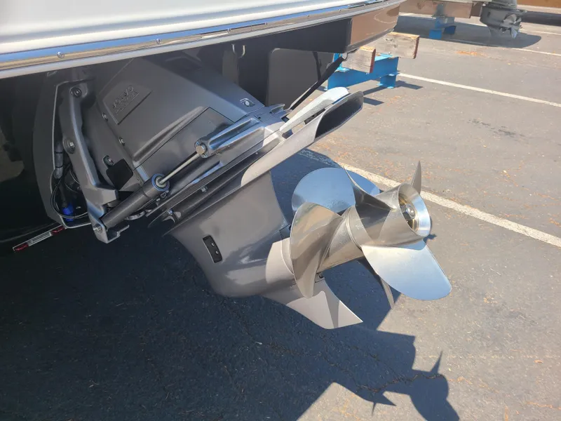 Slide: The Image of 2023 Four Winns HD3 boat propeller and outdrive in a parking lot. - 6