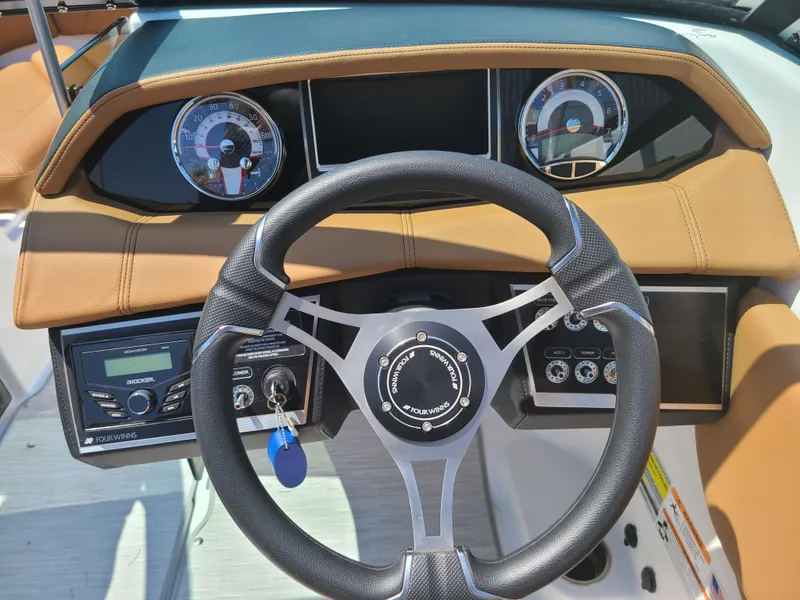Slide: The Image of 2023 Four Winns HD3 boat dashboard with steering wheel and instrument panel. - 12