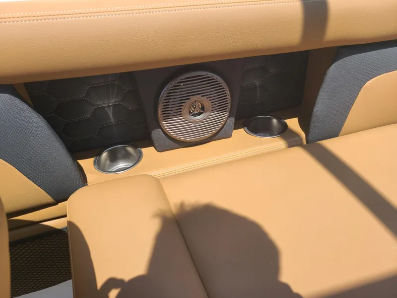 Slide: The Image of 2023 Four Winns HD3 boat interior with tan seating, speaker, and cup holders. - 17