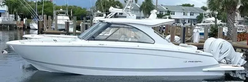 Slide: The Image of 2023 Regal LX36 boat docked in a marina, showcasing sleek design and modern features. - 1