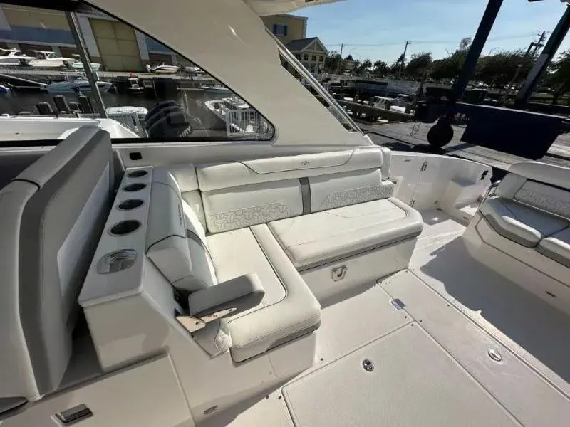 Slide: The Image of 2023 Regal LX36 boat interior with white seating and cup holders. - 12