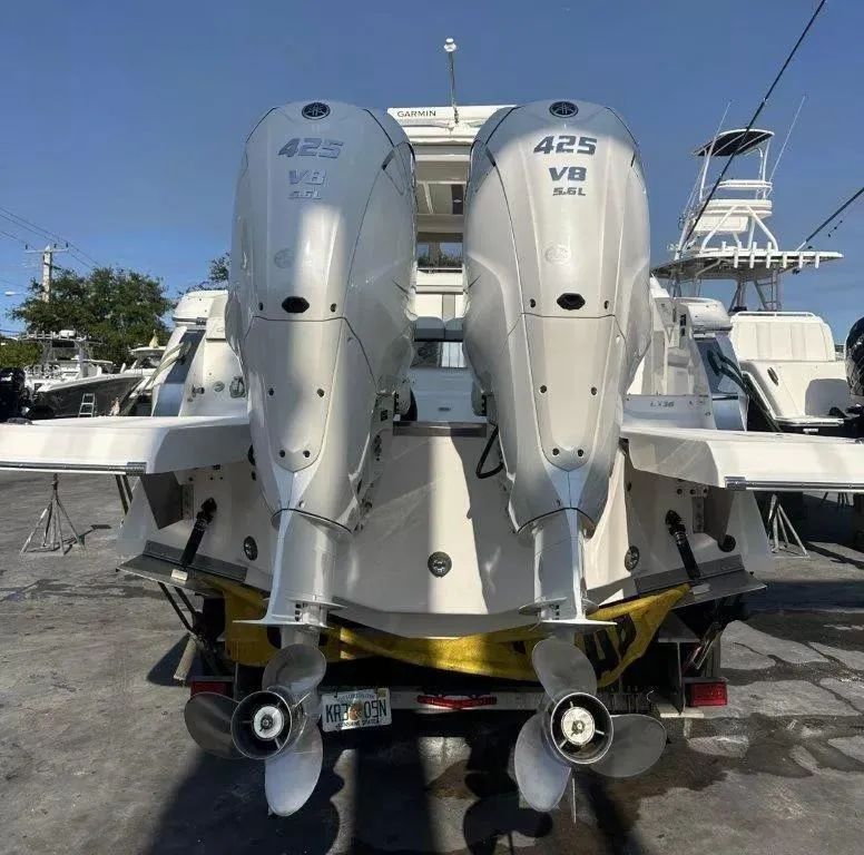 Slide: The Image of 2023 Regal LX36 boat with dual 425 V8 outboard engines, docked at a marina. - 17