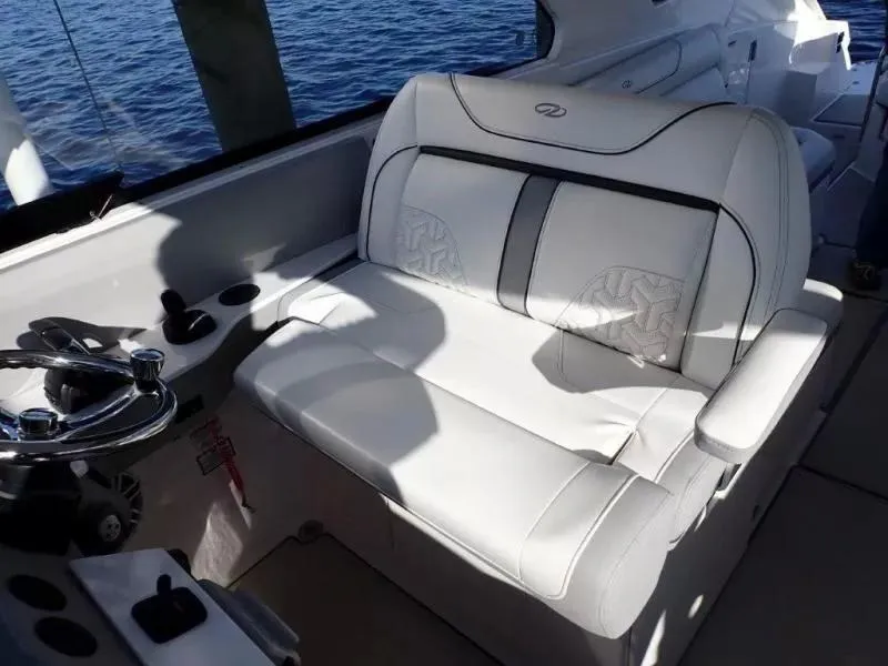 Slide: The Image of 2023 Regal LX36 boat interior with luxurious white seating and steering wheel. - 23