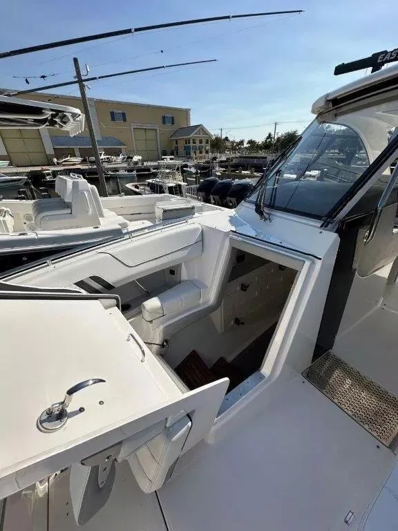 Slide: The Image of 2023 Regal LX36 boat interior with open cabin entrance, docked at marina. - 6