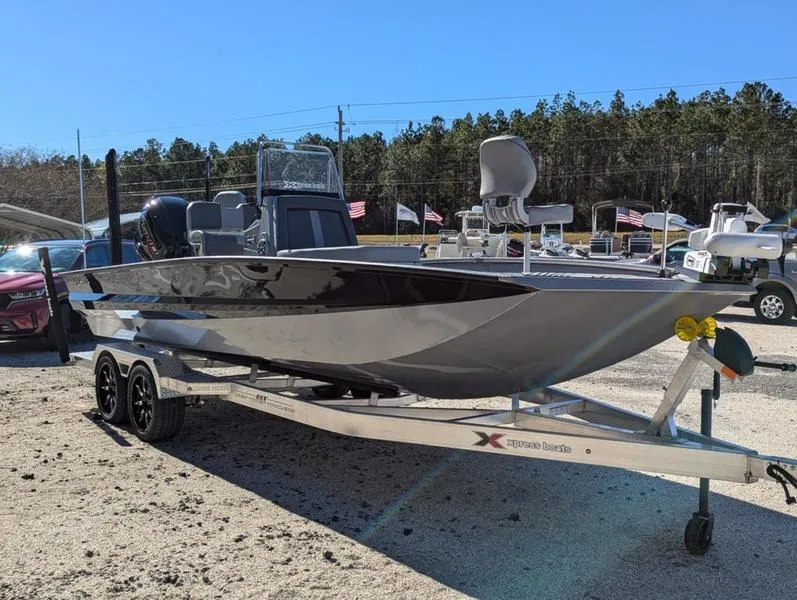 Slide: The Image of 2025 Xpress X23B Lounge boat on trailer, parked outdoors. - 1
