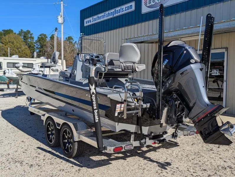 Slide: The Image of 2025 Xpress X23B Lounge boat on trailer outside dealership. - 14