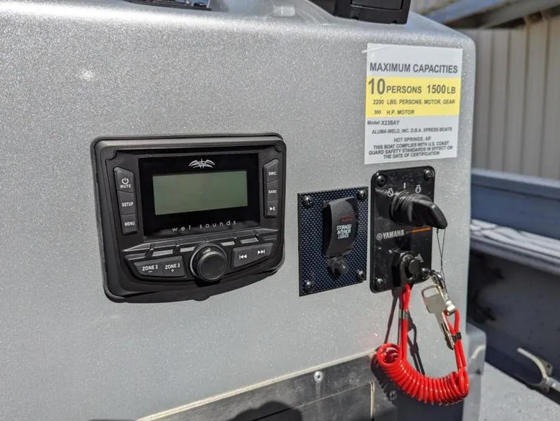 Slide: The Image of Control panel of 2025 Xpress X23B Lounge boat with capacity label and safety features. - 15