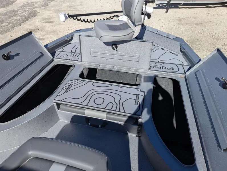 Slide: The Image of 2025 Xpress X23B Lounge boat interior with open storage compartments and seating. - 17