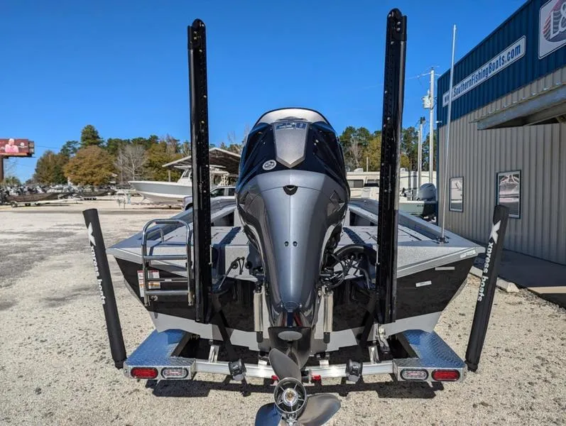 Slide: The Image of 2025 Xpress X23B Lounge boat with powerful outboard motor, parked outdoors. - 3