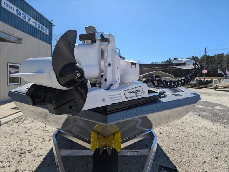 Slide: The Image of 2025 Xpress X23B Lounge boat with Minn Kota motor, parked outdoors. - 5