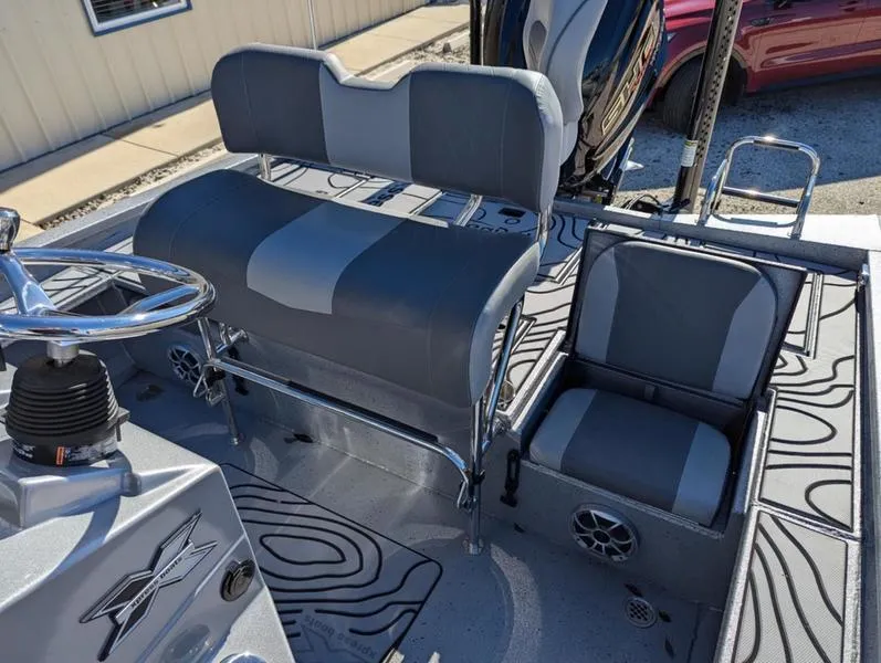 Slide: The Image of 2025 Xpress X23B Lounge boat interior with gray seating and steering wheel. - 9