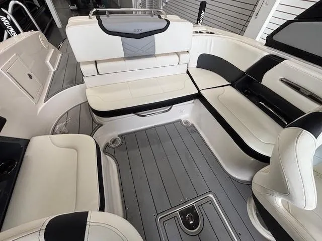 Slide: The Image of 2023 Chaparral 267 SSX boat interior with white and black seating, gray flooring. - 12