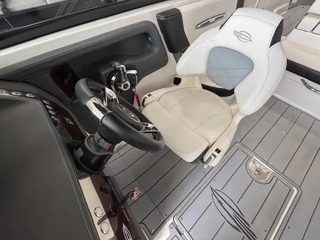 Slide: The Image of 2023 Chaparral 267 SSX boat interior with steering wheel and white captain's chair. - 13