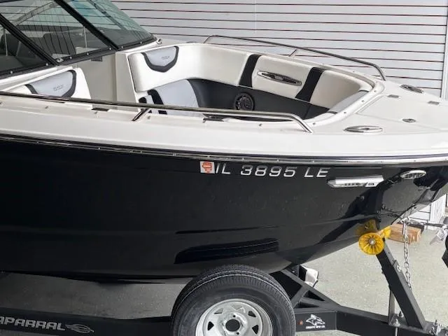 Slide: The Image of 2023 Chaparral 267 SSX boat on trailer, black hull, white interior, side view. - 15