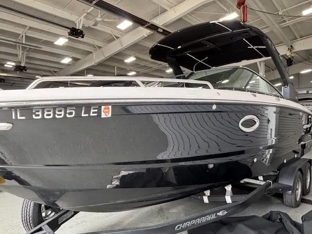 Slide: The Image of 2023 Chaparral 267 SSX boat in showroom, sleek black design, on trailer. - 2
