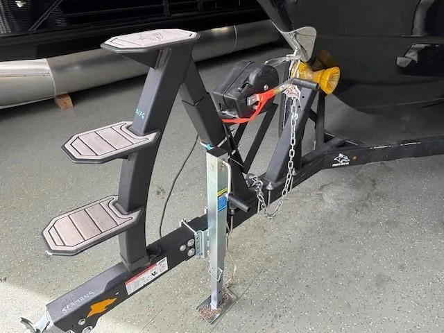 Slide: The Image of Trailer hitch and steps of 2023 Chaparral 267 SSX boat on pavement. - 22