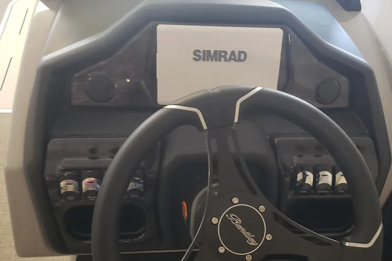 Slide: The Image of 2025 Bentley Pontoons Elite Admiral dashboard with Simrad display and steering wheel. - 18