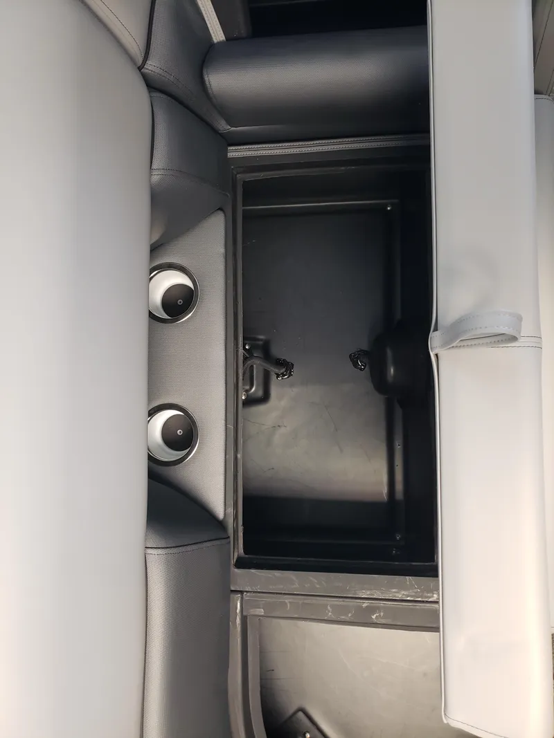 Slide: The Image of 2025 Bentley Pontoons Elite Admiral storage compartment with cup holders and sleek interior design. - 9