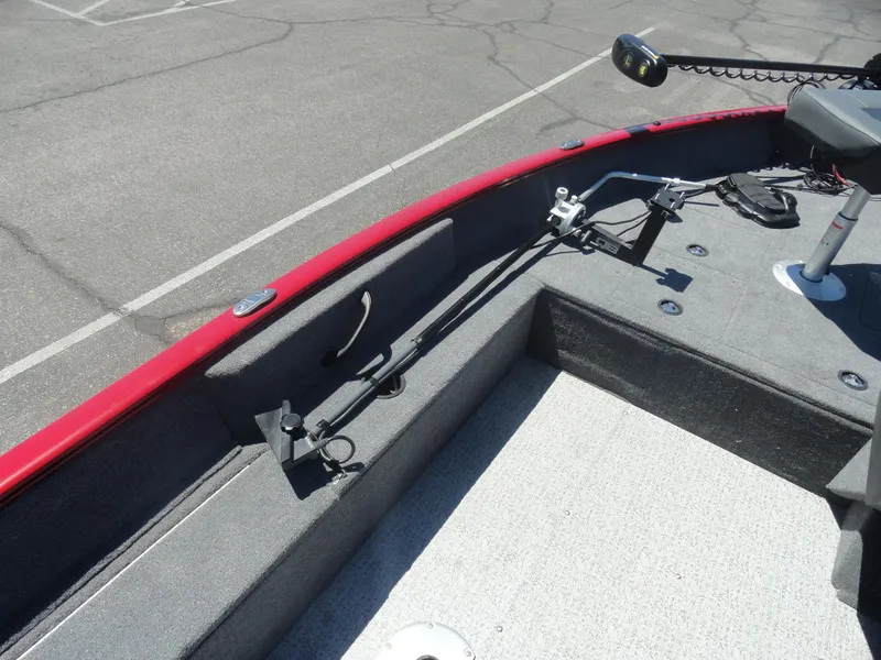 Slide: The Image of 2024 Tracker Pro Guide V-16 SC boat interior with red trim and fishing rod holder. - 12