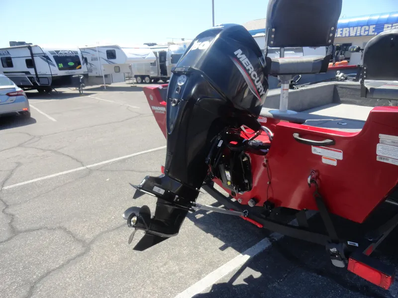 Slide: The Image of 2024 Tracker Pro Guide V-16 SC boat with Mercury outboard motor in parking lot. - 21