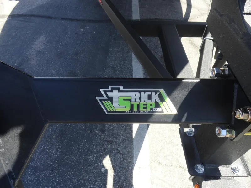 Slide: The Image of 2024 Tracker Pro Guide V-16 SC trailer with Trick Step branding, black metal frame. - 5