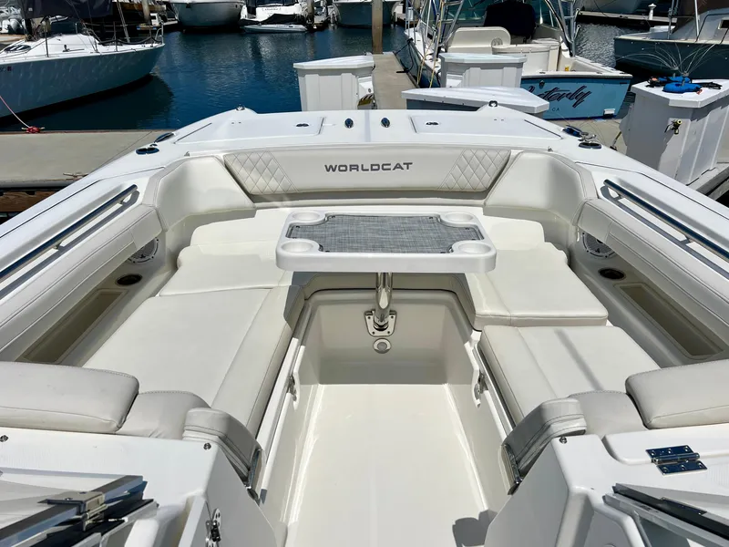 Slide: The Image of 2024 World Cat 280DC-x boat interior with seating and table, docked at marina. - 17
