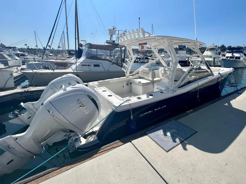 Slide: The Image of 2024 World Cat 280DC-x boat docked at marina with twin engines. - 2