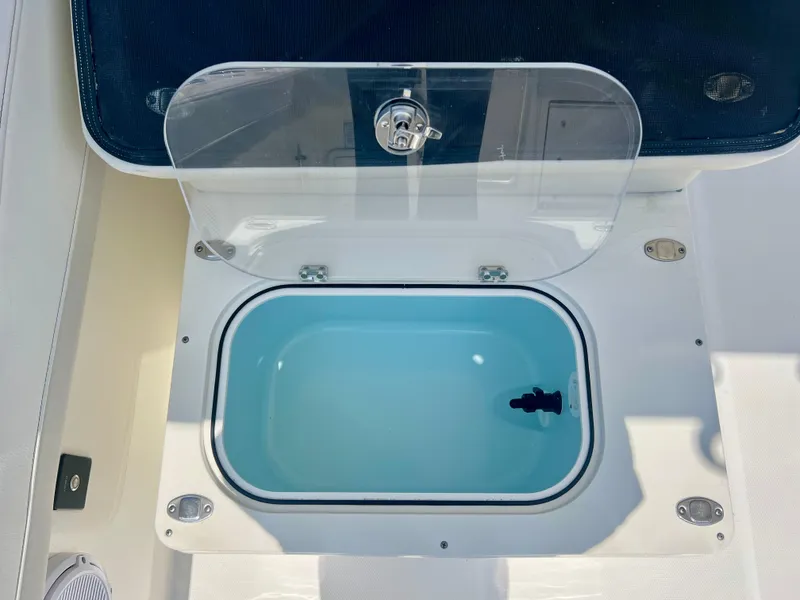 Slide: The Image of Livewell compartment on 2024 World Cat 280DC-x boat, featuring a clear lid and blue interior. - 23