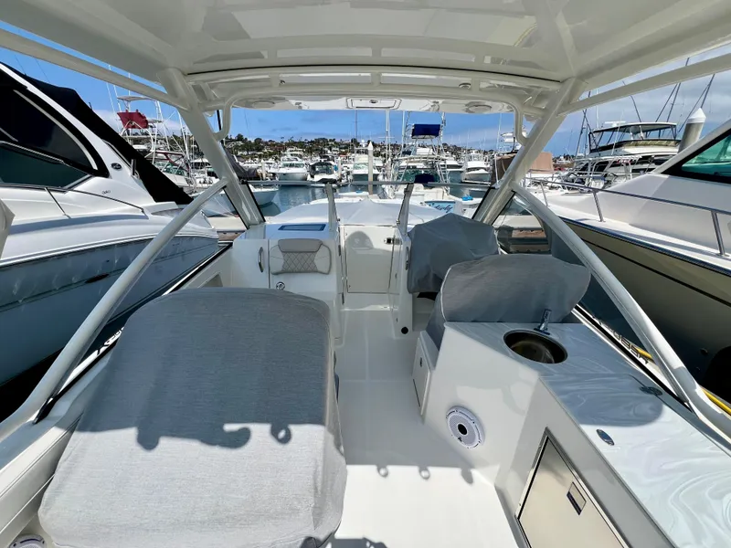 Slide: The Image of 2024 World Cat 280DC-x boat interior with covered seats, docked in a marina. - 7