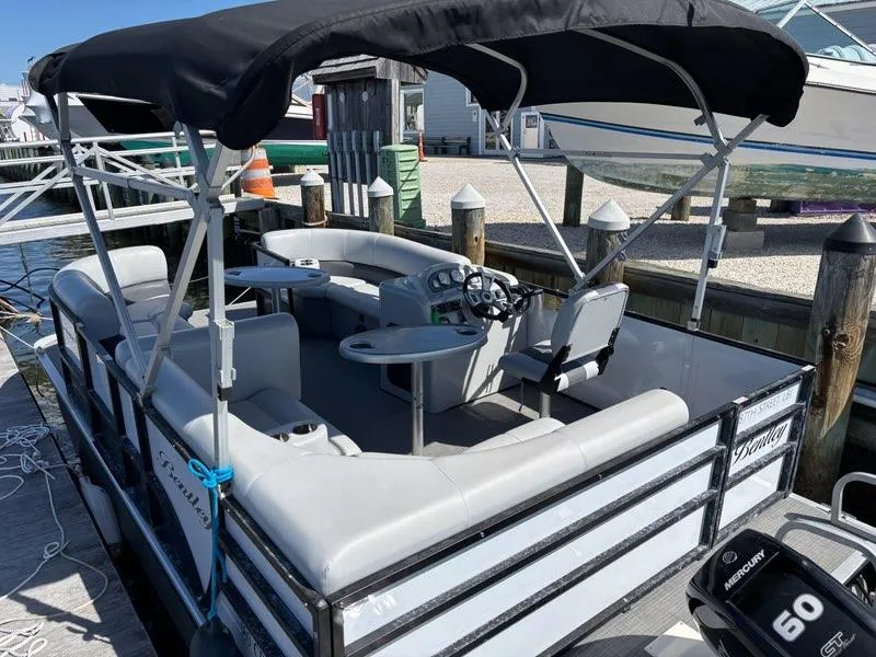 Slide: The Image of 2020 Bentley Pontoons LE 180 Cruise at dock, featuring spacious seating and canopy. - 3