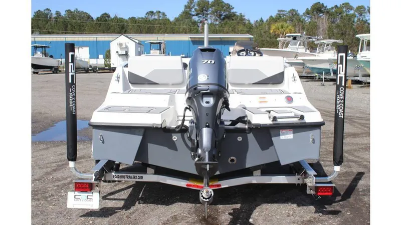 Slide: The Image of 2025 Starcraft SV 16 OB boat with outboard motor, parked on a trailer in a marina. - 3